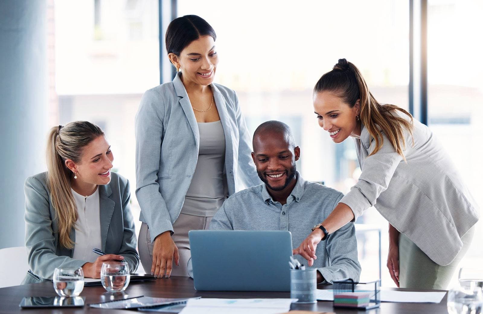 Colleagues discussing work around a laptop